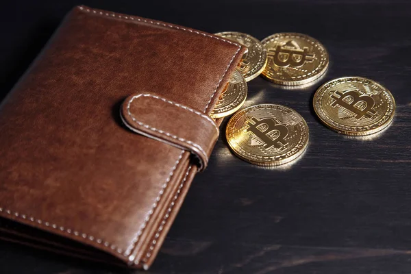 Bitcoins de oro en cartera sobre fondo oscuro . — Foto de Stock