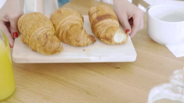 Frauenhände Legen Ein Holzbrett Mit Leckeren Croissants Auf Den Tisch — Stockvideo