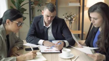 Bir grup başarılı genç modern bir ofiste yeni bir projeyi tartışıyor.