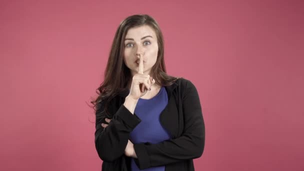 一个有手指在嘴唇上的严格女人的画像 年轻女子要求沉默 做了一个沉默的手势 — 图库视频影像