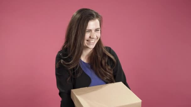 快乐的女人拿着粉红背景的盒子 — 图库视频影像