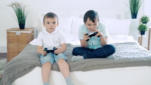 两个朋友或兄弟笑着和控制器一起玩电子游戏 玩得很开心 — 图库视频影像