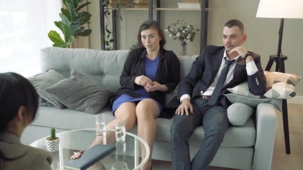 Mladý pár mluví se specialistou nebo konzultantem v moderní kanceláři — Stock video