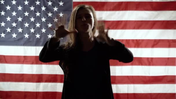 Amerikan Bayrağının Arka Planında Konuşan Kol Hareketi Yapan Bir Kadın — Stok video