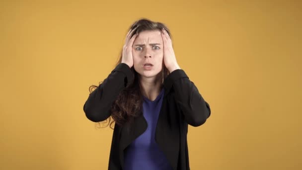 Young Frightened Woman Clutching Her Head Yellow Background — Stock Video