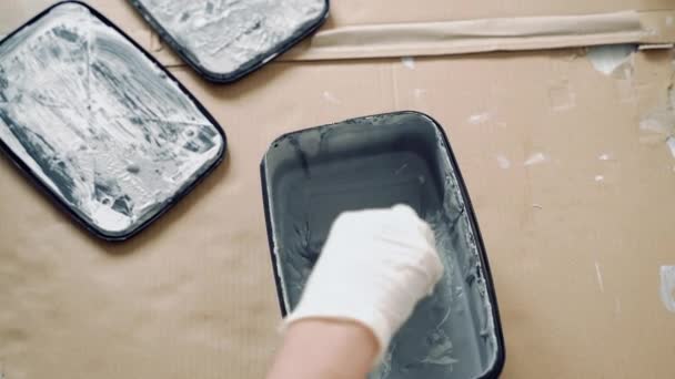 灰色の塗料や石膏をヘラで混合手袋を手のクローズアップ — ストック動画