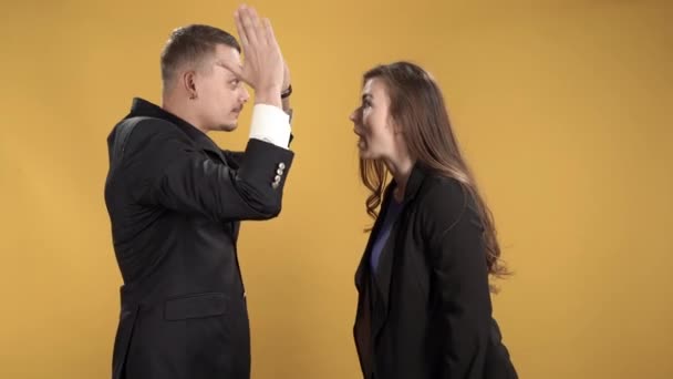 若いカップルが物事を理解し 黄色の背景にカーシングとジェスチャー — ストック動画