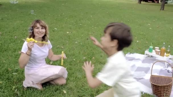 Happy Mother Her Two Kids Playing Together Blowing Catching Soap — Stock Video