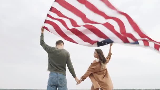 幸せなカップルは 自然の中でアメリカのフラグを保持 独立記念日 ライフスタイル 旅行のコンセプト — ストック動画