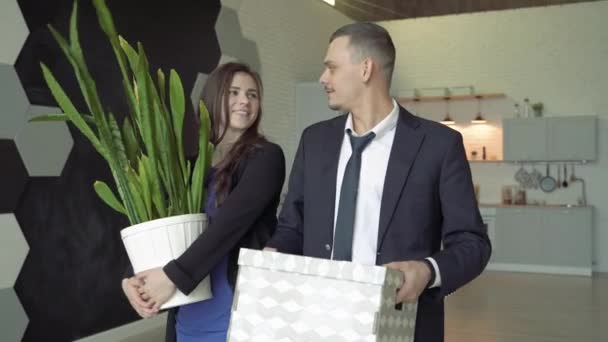 幸福的夫妇带着盒子和鲜花在新公寓里 年轻人笑着拥抱 — 图库视频影像