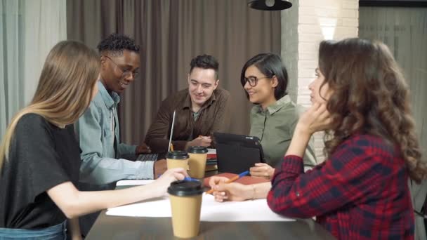 一群多种族的学生或同事一起在咖啡馆或办公室里笑着说笑话 — 图库视频影像