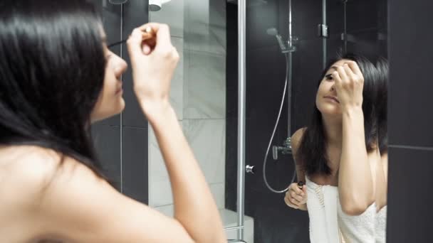 Ελκυστική Νεαρή Γυναίκα Κοιτάζει Στον Καθρέφτη Και Απλώνει Μάσκαρα Στα — Αρχείο Βίντεο