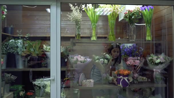 Ung Kvinna Florist Korrigera Buketter Blommor Och Växter Ett Fönster — Stockvideo