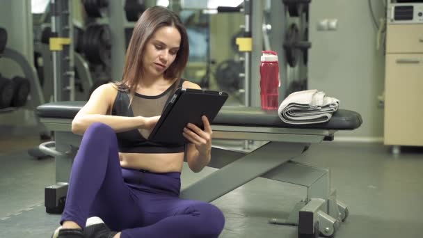 Genç Gülümseyen Bayan Antrenör Spor Salonunda Tablet Bilgisayar Kullanarak Çevrimiçi — Stok video