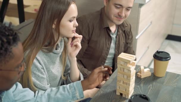 Ομάδα Χαρούμενων Φίλων Που Παίζουν Παιχνίδι Αφαίρεσης Μπλοκ Στο Σαλόνι — Αρχείο Βίντεο