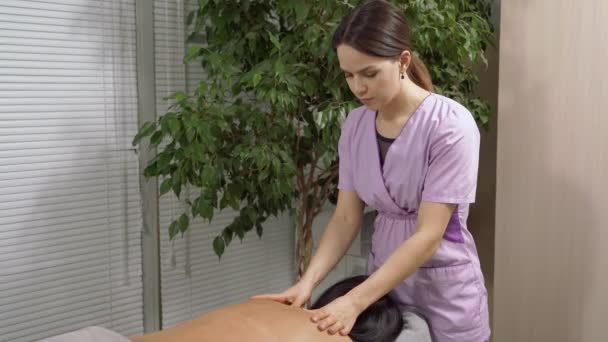 Kobieta Masażystka Robi Masaż Pleców Młodej Brunetki Gabinecie Medycznym — Wideo stockowe
