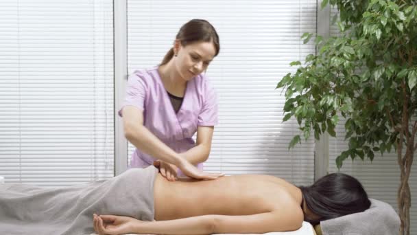 Kvinna Massage Terapeut Gör Rygg Massage Till Ung Brunett Ett — Stockvideo