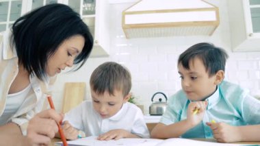 Annem iki oğlana albümde işaret çizmeleri için yardım ediyor. Okul öncesi eğitim