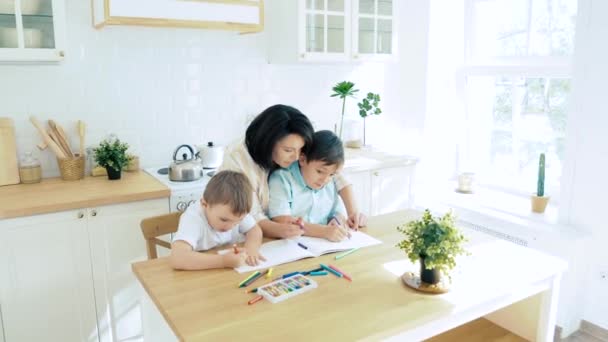 Mãe Ajudando Dois Filhos Desenhar Com Canetas Feltro Papel Cozinha — Vídeo de Stock