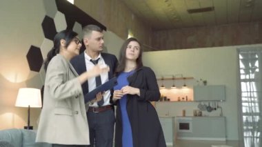 Profesyonel emlakçı genç çifte ev ya da daire sunuyor. Yeni mülke bakan ve ev sahibi olmaya hazır genç çift..