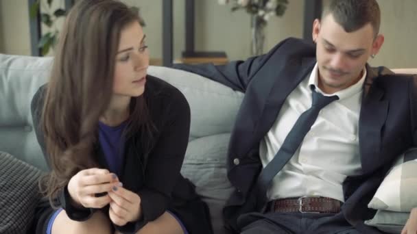 Junges Paar Sitzt Auf Einer Couch Und Spricht Mit Einem — Stockvideo