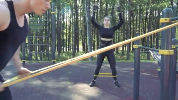 Jong Atletisch Paar Doen Oefening Met Elastische Banden Buiten — Stockvideo