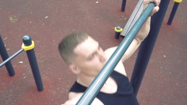 Young athletic man doing push-ups on bars outdoors — Stock Footage Young Athletic Man Doing Push Ups Bars Outdoors Video Clip