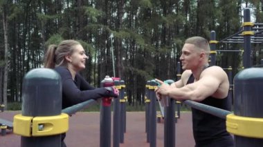 İki genç sporcu dışarıda egzersiz yaptıktan sonra dinleniyorlar..