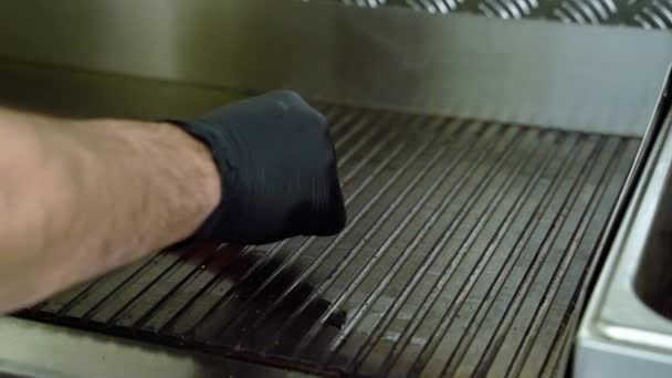 Cuisiner des hamburgers. Les mains de Cook posant des morceaux de bacon dans la casserole 