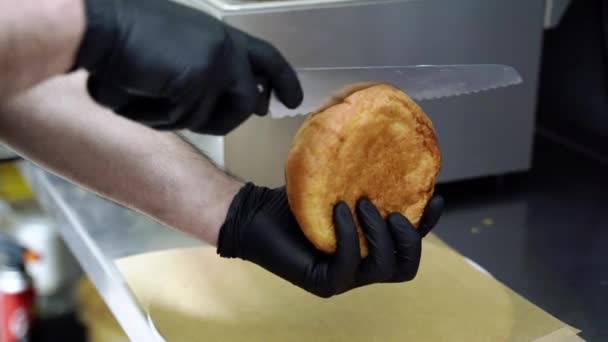 Close Van Chef Kok Handen Snijden Een Hamburger Broodje — Stockvideo