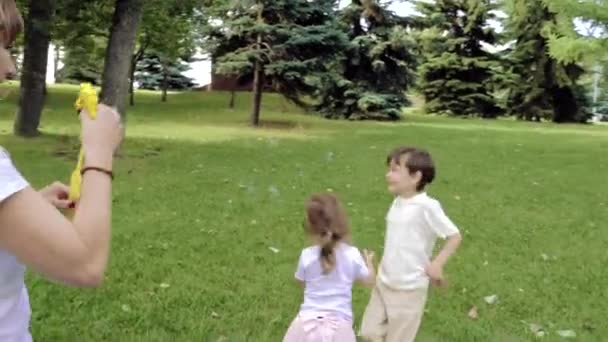 Feliz Madre Sus Dos Hijos Jugando Juntos Soplando Atrapando Burbujas — Vídeos de Stock