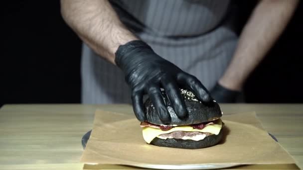 Mãos Chef Cozinhar Delicioso Hambúrguer Preto Com Bacon Defumado Molho — Vídeo de Stock