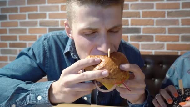 Szczęśliwa Para Jedząca Hamburgery Kawiarni Lub Domu — Wideo stockowe