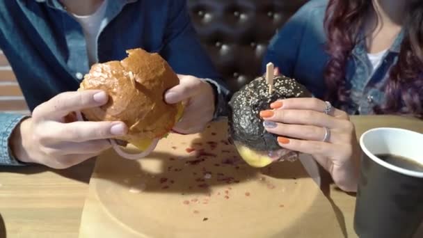 Zbliżenie Dwóch Pysznych Hamburgerów Rękach Młodej Pary — Wideo stockowe