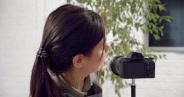 Popüler kadın bahçıvan blog yazarı kamerayı açıyor aboneleri selamlıyor ve bir ev bitkisinin bakımıyla ilgili bir video kaydediyor..