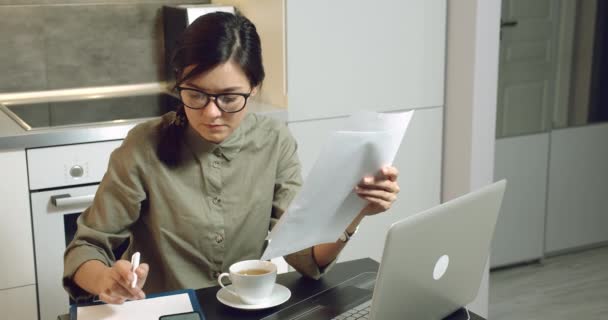 ビジネスの女性は家で文書を読み ノートパソコンで働く計算をする 距離作業 — ストック動画