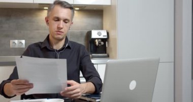 Genç iş adamı, ortaklar veya müşterilerle video bağlantısı yoluyla konuşuyor. Evde kulaklık ve dizüstü bilgisayar kullanarak bir sözleşmenin ya da yeni bir projenin şartlarını tartışıyorlar.