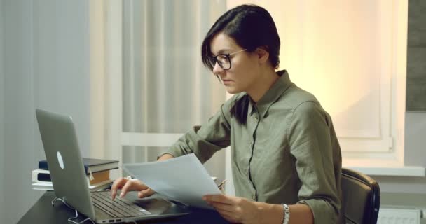 Mujer Joven Enfocada Leyendo Contrato Informe Cuidadosamente Trabajando Una Computadora — Vídeo de stock