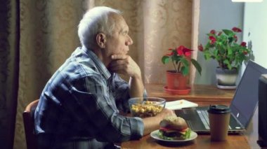 Haberleri okuyan ya da akşam evde dizüstü bilgisayar başında çalışan yaşlı bir adam.