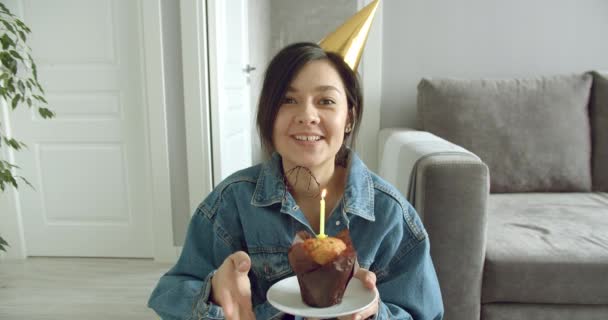 一个快乐的年轻女人在家里独自一个人在蛋糕上吹灭蜡烛 视频聊天 庆祝生日的肖像 — 图库视频影像