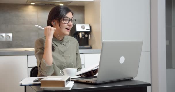 Biznesmenka Rozmawia Przez Komunikację Wideo Pomocą Słuchawek Laptopa Robi Notatki — Wideo stockowe