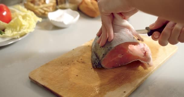 在厨房的木板上 一个厨师正在切一片新鲜的鲑鱼鱼 她紧紧地握住女厨师的手 — 图库视频影像