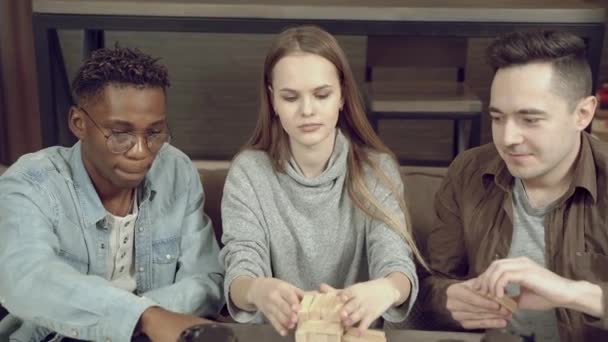 Groep Van Gelukkige Vrienden Spelen Blok Verwijdering Spel Woonkamer Thuis — Stockvideo