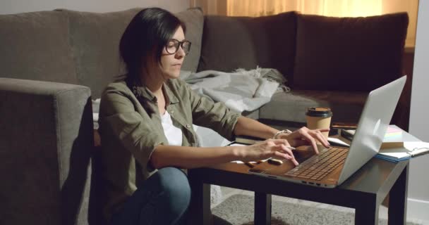 Mujer Joven Freelancer Concentrada Con Gafas Mecanografiando Trabajando Portátil Mientras — Vídeo de stock