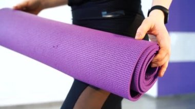 Mor yoga Mat 'in yakın çekimi kadınların ellerinde..