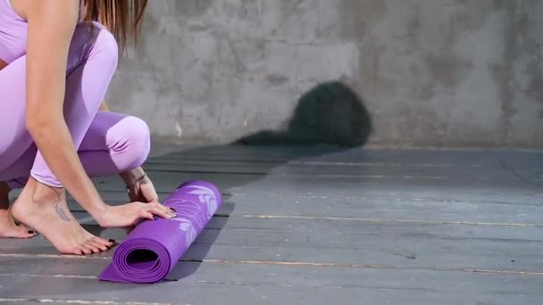 Ung Kvinna Vecklar Matta För Yogautövande Ateljén — Stockvideo