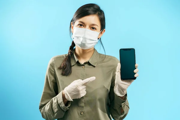Portrait Young Woman Protective Medical Mask Gloves Pointing Screen Smartphone — Stock Photo, Image