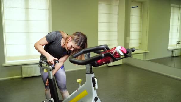 Νεαρή Γυναίκα Προετοιμασία Ποδήλατο Άσκηση Πριν Από Την Άσκηση Καρδιο — Αρχείο Βίντεο
