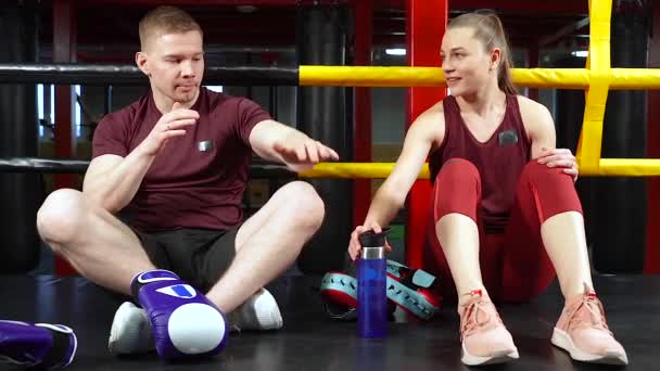 私人教练向一位年轻女子解释拳击训练的技巧 — 图库视频影像