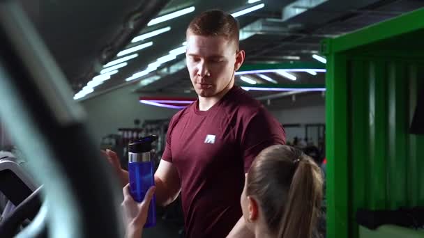 Young Woman Bringing Water Bottle Man Working Stationary Bike — Stock Video